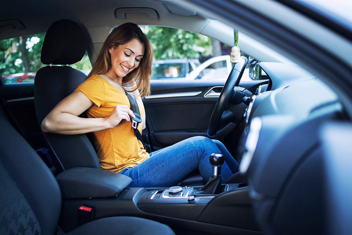 female driver putting seat belt