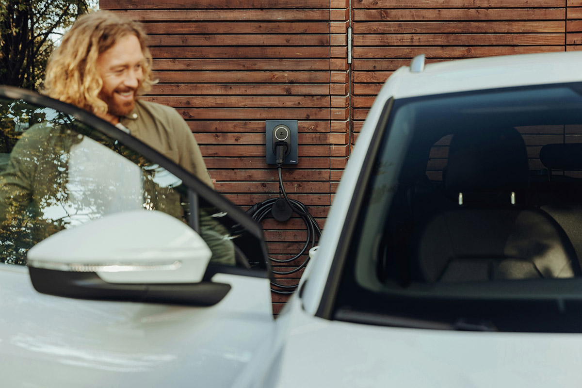 man standing next to a white car